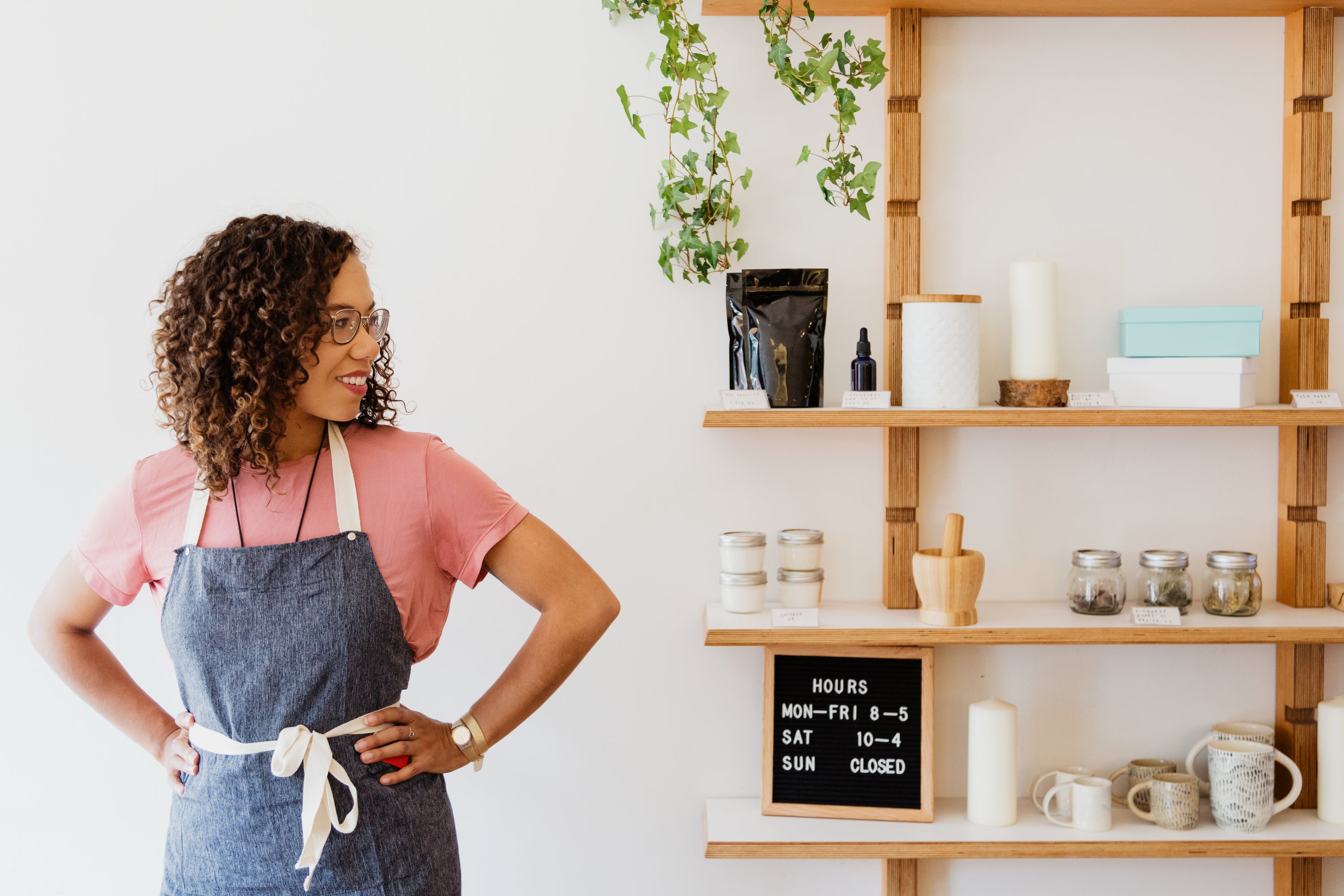 A woman arranging products in her shop showcasing MelloBox lifestyle and gift items